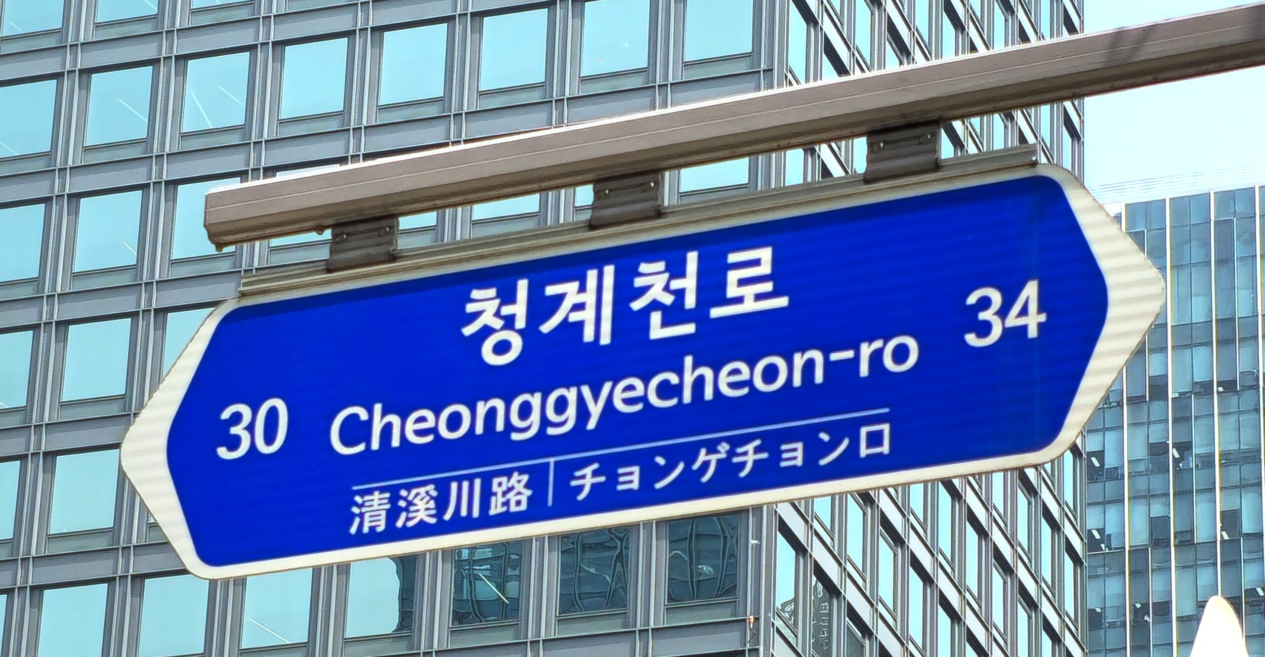 Blue Cheonggyecheon-ro road sign in Seoul showing the Korean road name, romanization and building-number range.