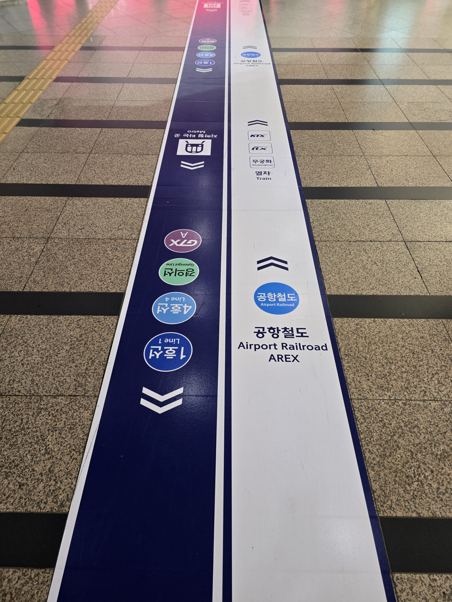 空港鉄道AREXを示すソウル駅の青と白の床案内線。
