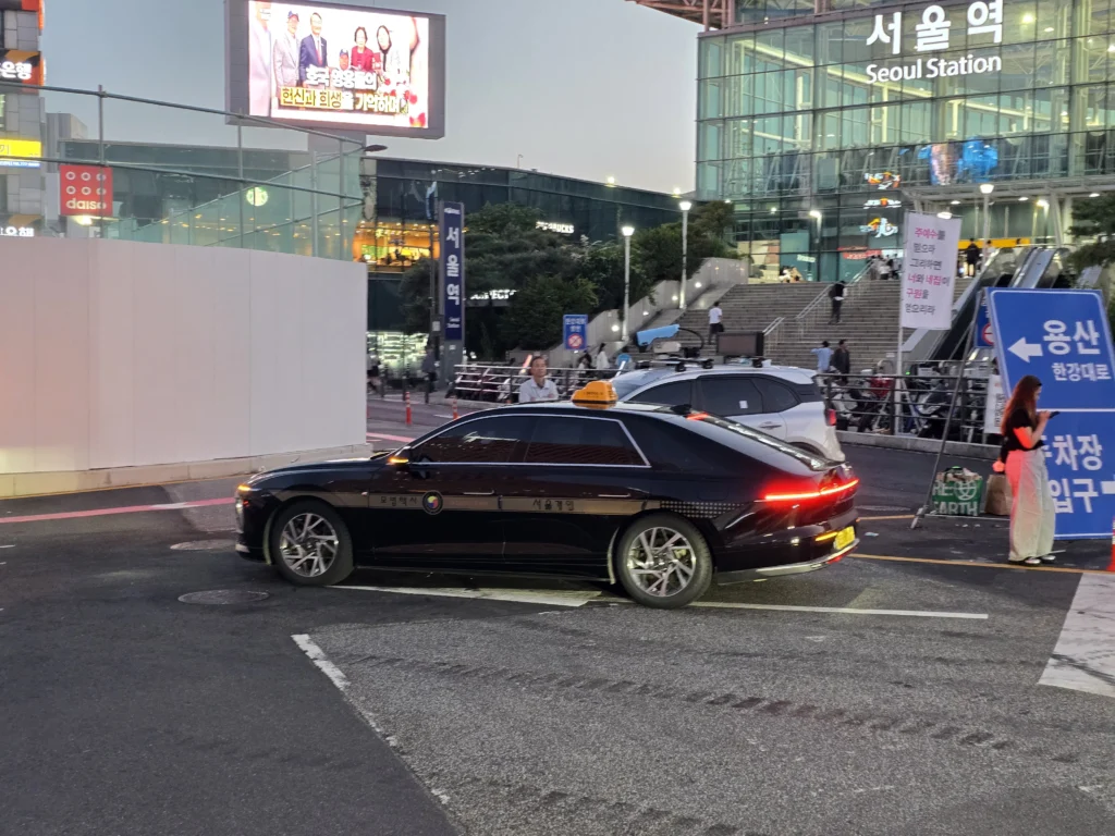 ソウル駅前にある모범택시表示の黒い模範タクシー。