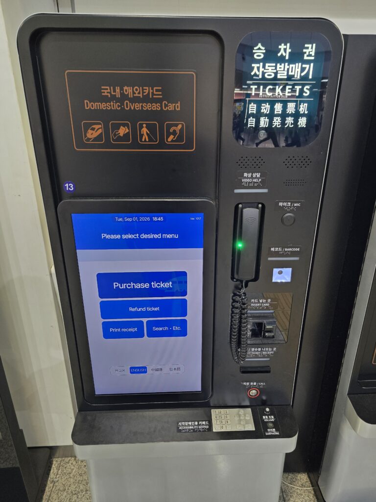 KORAIL ticket vending machine at Seoul Station with an English screen and a sign for domestic and overseas cards.